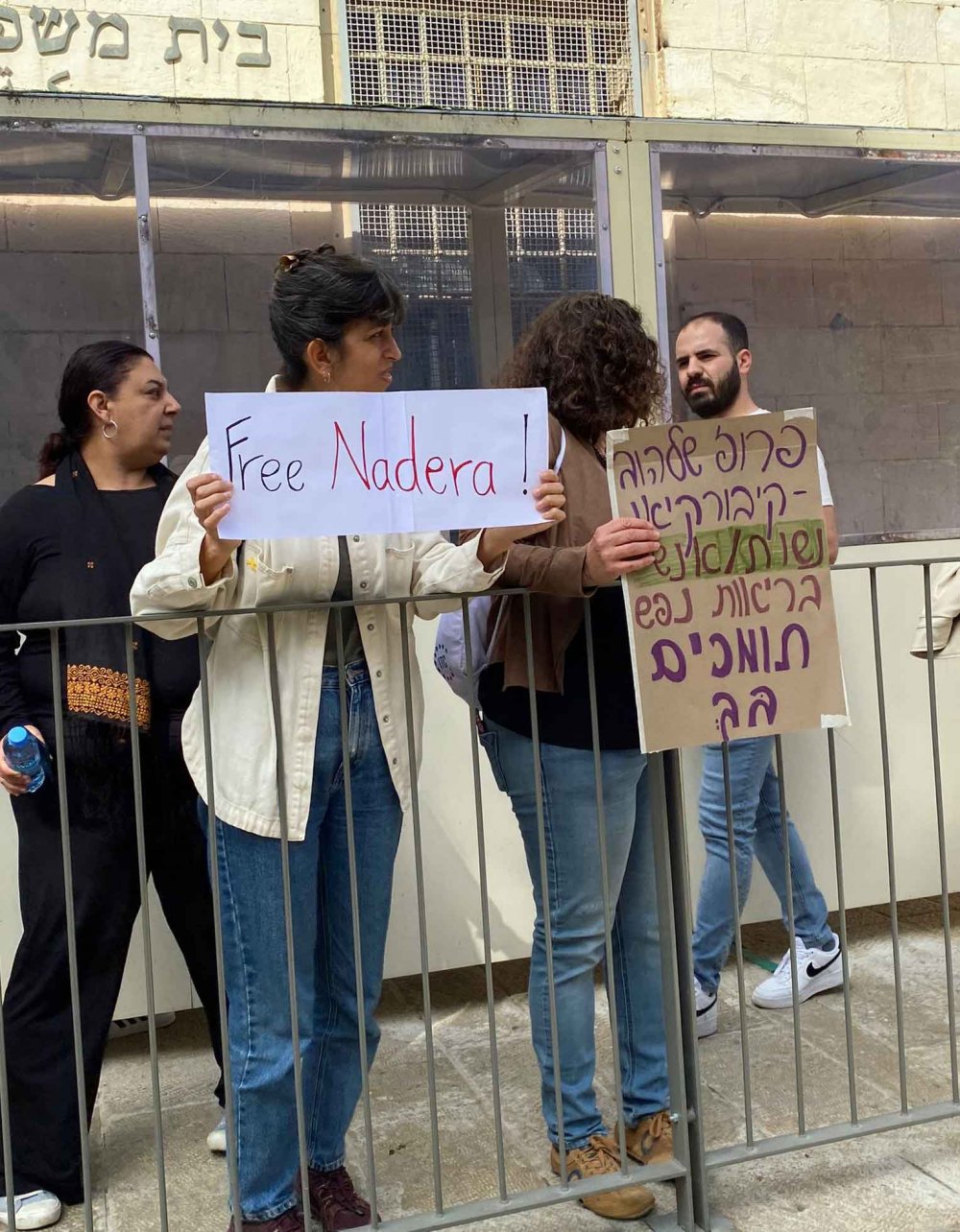 Demonstrators hold signs outside the Jerusalem court in support of Dr. Nadera Shalhoub-Kevorkian’s release, March 19, 2024.