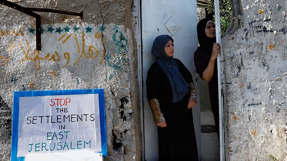 A Palestinian family looks out from their home on a protest against home expulsions, Sheikh Jarrah, August 4, 2017.