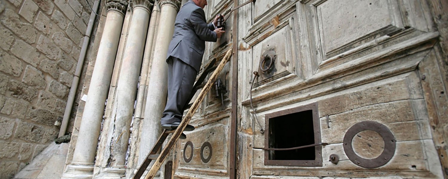 Wajih Nusseibeh climbs the ladder to open the doors of the Church of the Holy Sepulchre, April 7, 2007.