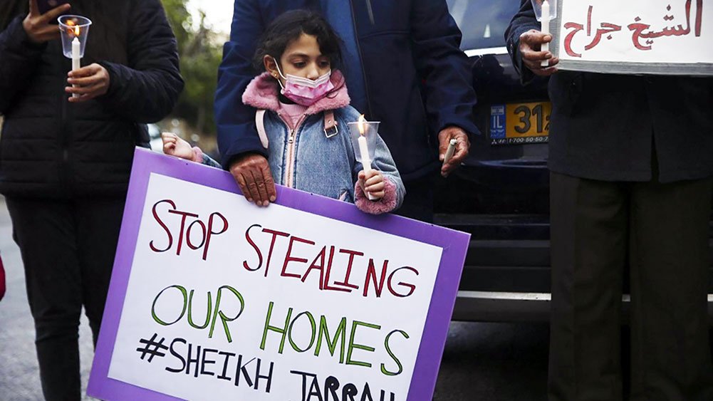 Palestinian child holds poster saying “Stop Stealing Our Homes” during March 2021 protest in Sheikh Jarrah, East Jerusalem.