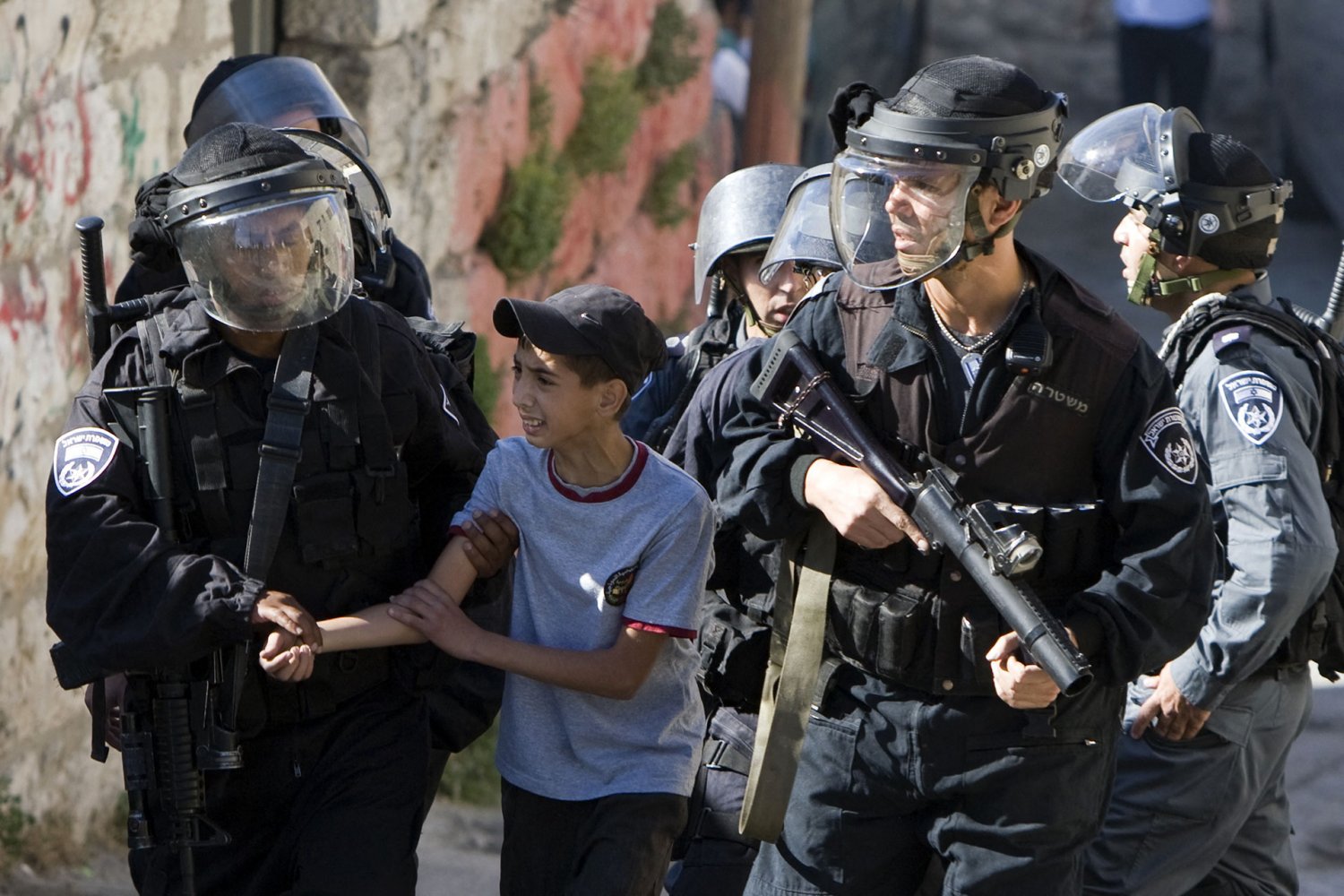 Israeli riot policemen arrest a Palestinian boy in East Jerusalem.