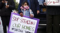 Palestinian child holds poster saying “Stop Stealing Our Homes” during March 2021 protest in Sheikh Jarrah, East Jerusalem.