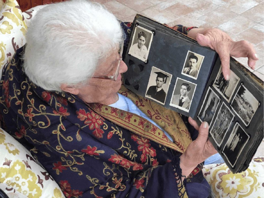 Abla looks at one of the photo albums she was able to salvage from her family home.