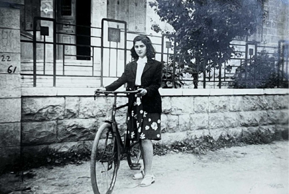 Abla Dajani Daoudi stands near her home in Lower Baq‘a, Jerusalem, 1943.