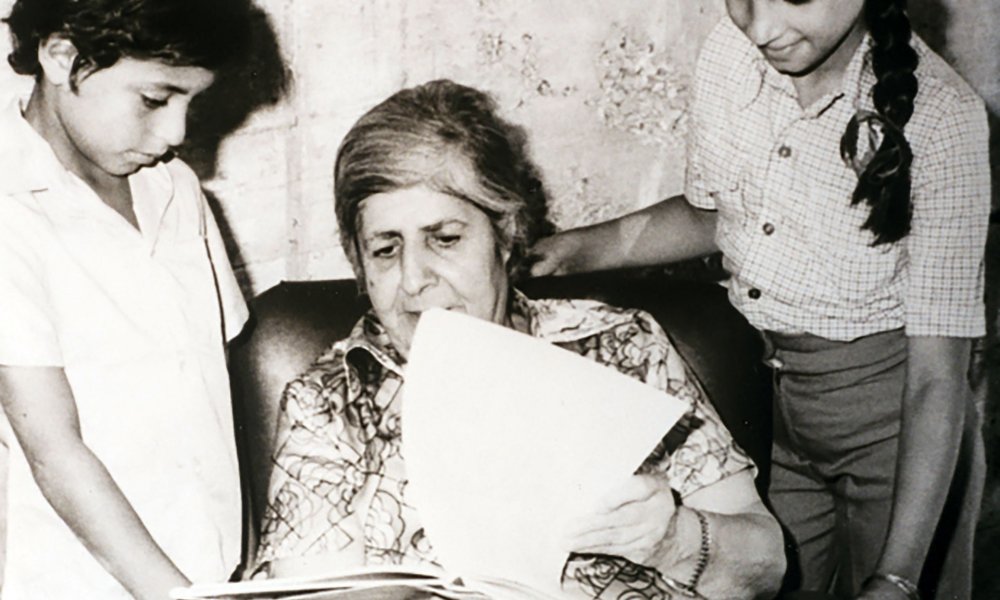 Founder Elizabeth Nasir inspects a book with two young students at Rawdat El-Zuhur school in Jerusalem, 1977.