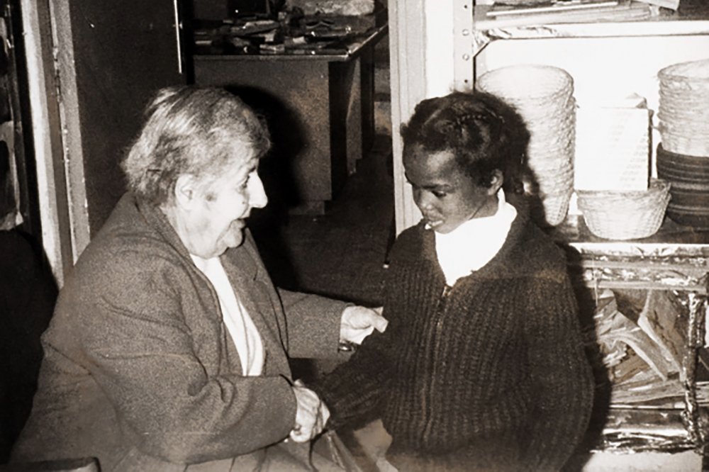 Elizabeth Nasir, founder of Rawdat El-Zuhur school in Jerusalem, shakes hands with students, 1975.