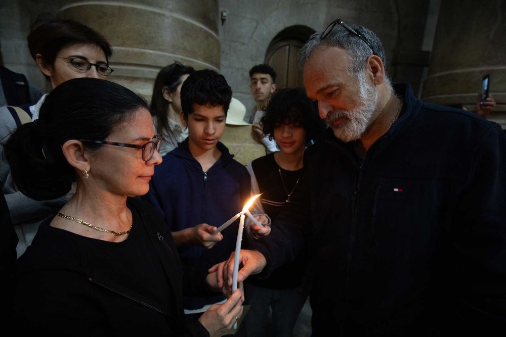 Catholic worshippers light candles together on Easter service in the Church of the Holy Sepulchre, March 31, 2024.