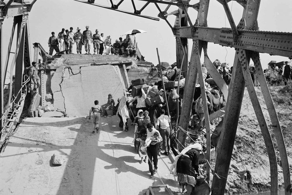 Palestinians fleeing the war in June 1967 throng the Allenby Bridge crossing to Jordan while Israeli soldiers look on