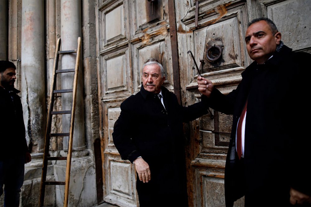 Wajih Nusseibeh and Adeeb Judeh open the doors to the Church of the Holy Sepulchre, March 30, 2018.