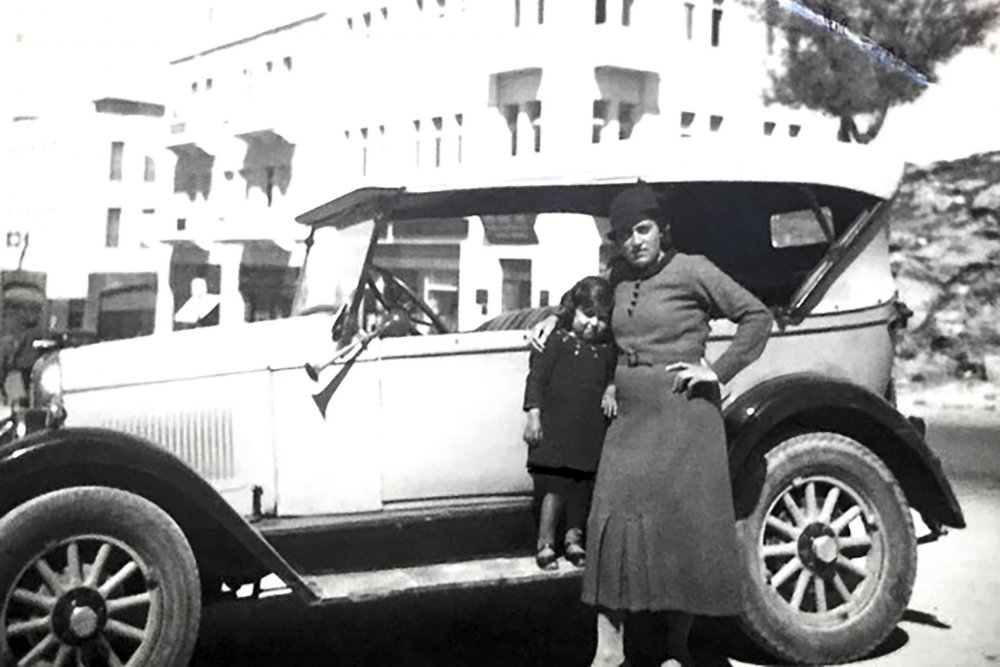 Palestinian women pose next to a family car in Jerusalem before Israel was established. 