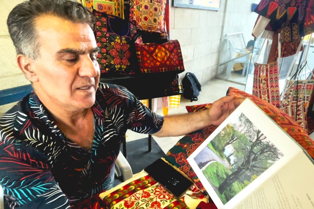 Issa Qawasmi shows his work at the Yabous Cultural Centre bazaar, Jerusalem, August 2024.