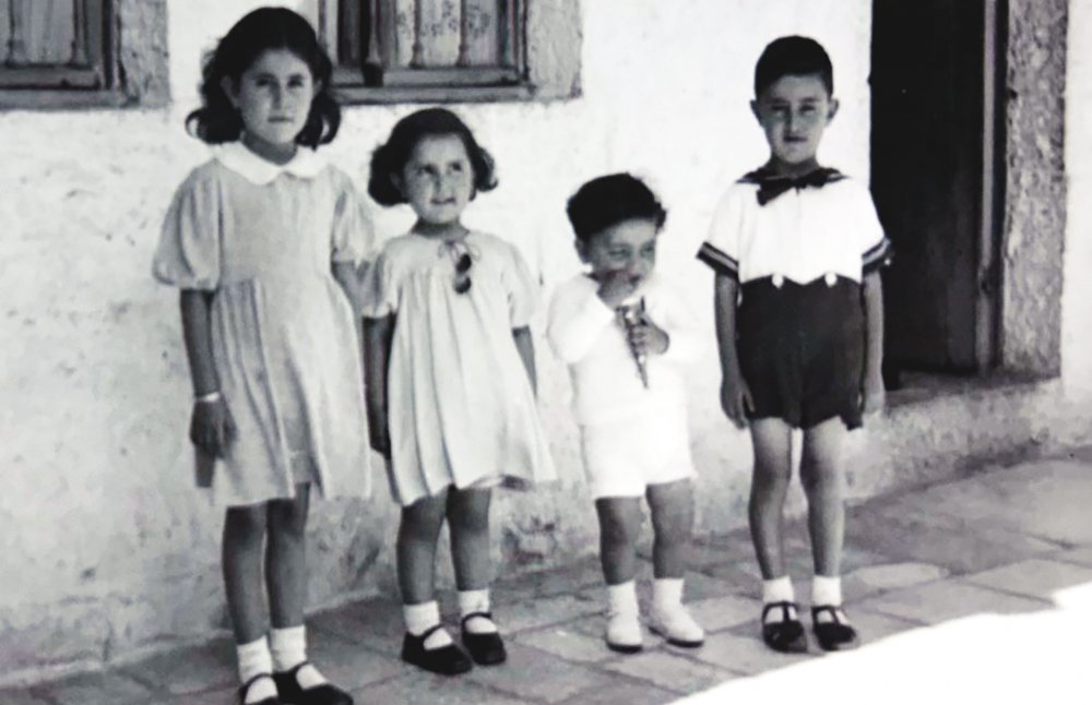 Four children stand for a photograph in their house, before the establishment of Israel. 