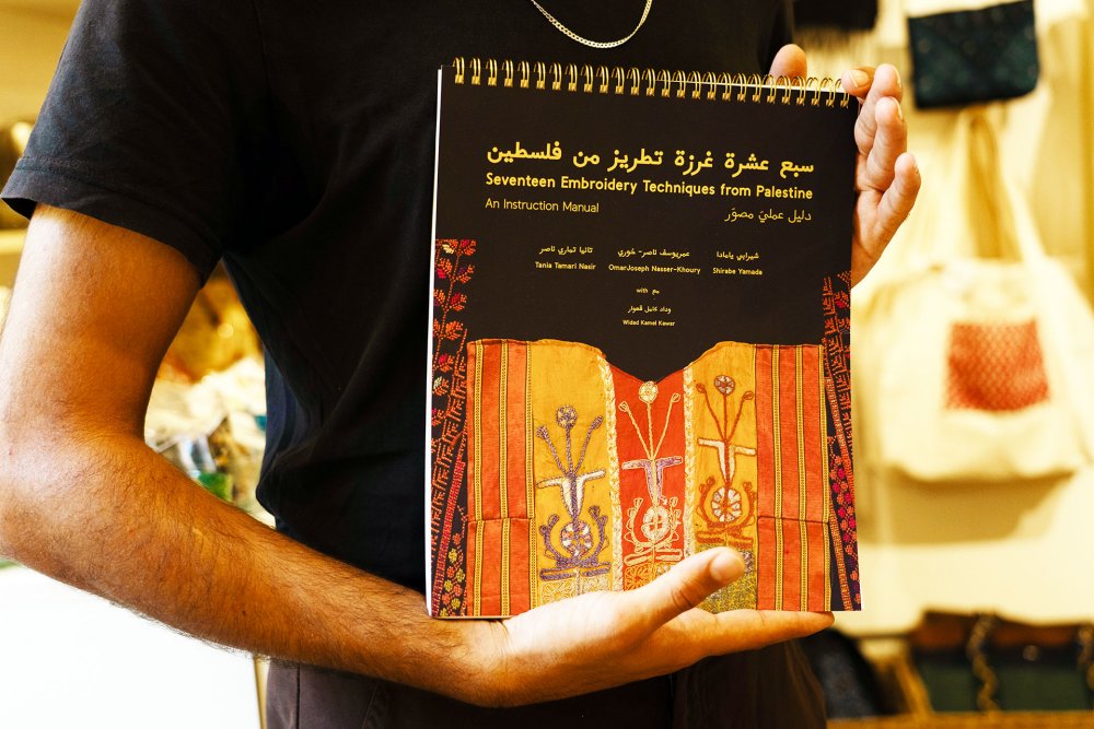 Sunbula’s instruction manual on Palestinian embroidery is displayed at its Jerusalem shop, August 21, 2024