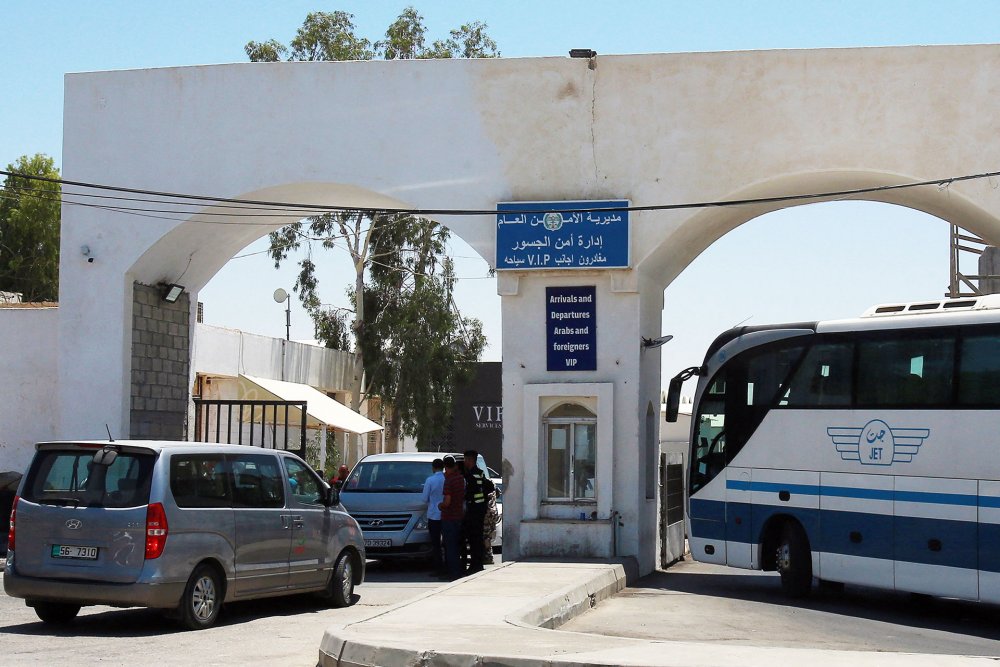 Vehicles wait on the Jordanian side of the King Hussein Bridge, July 19, 2022