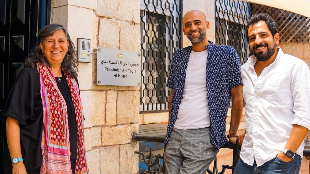 Colleagues Reem, Ahed, and Tarek stand in front of their workplace, the Palestinian Art Court—al-Hoash, Jerusalem, June 24, 2024.