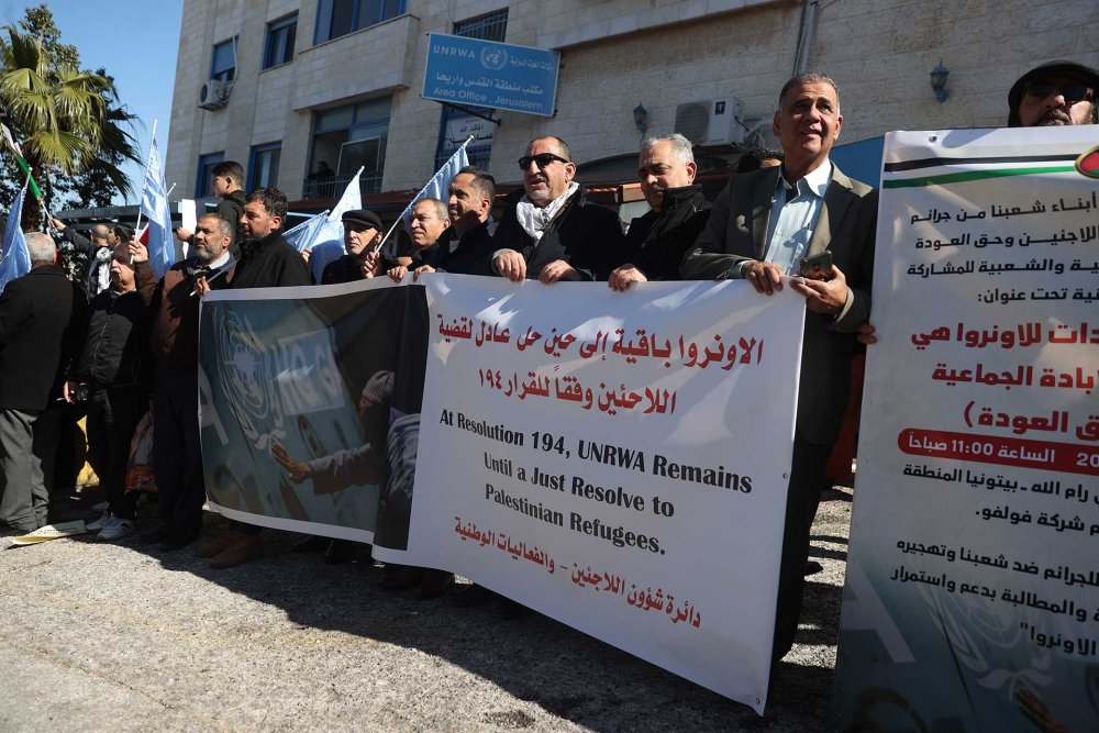 Palestinians hold banners protesting the suspension of donor funding for UNRWA, Ramallah, West Bank, February 7, 2024.