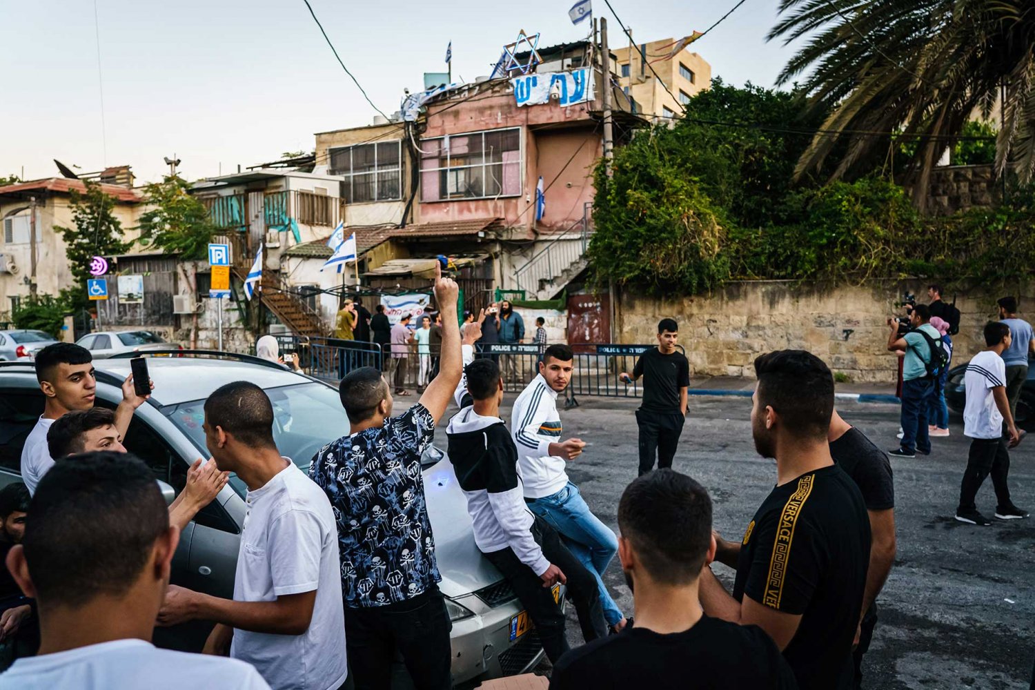 Palestinians celebrate the release of Muna al-Kurd as settlers watch, June 6, 2021.