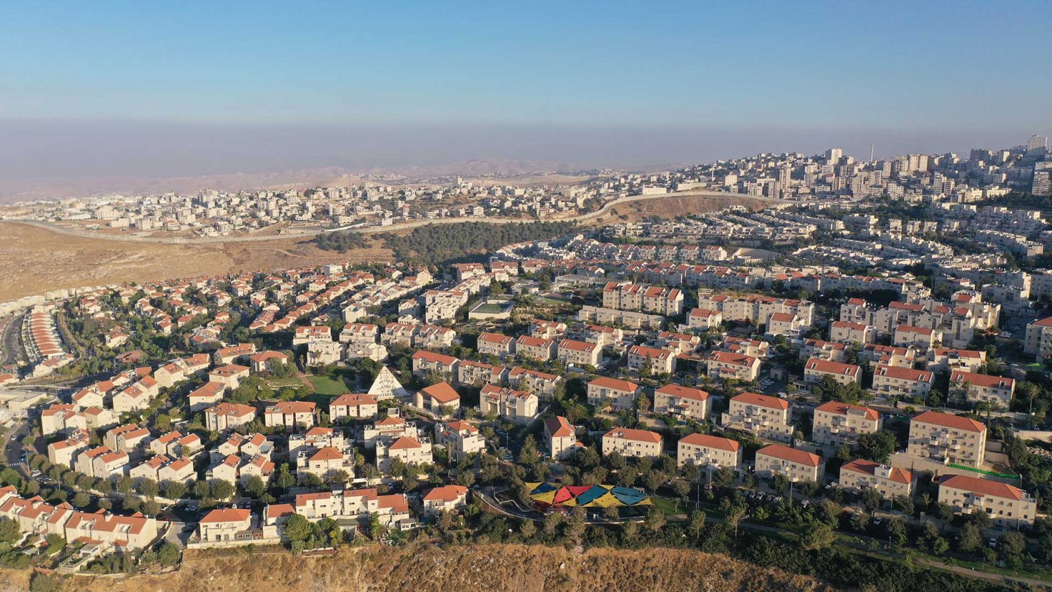 Pisgav Zeev settlement in Jerusalem—‘Anata Palestinian refugee camp walled off in the distance