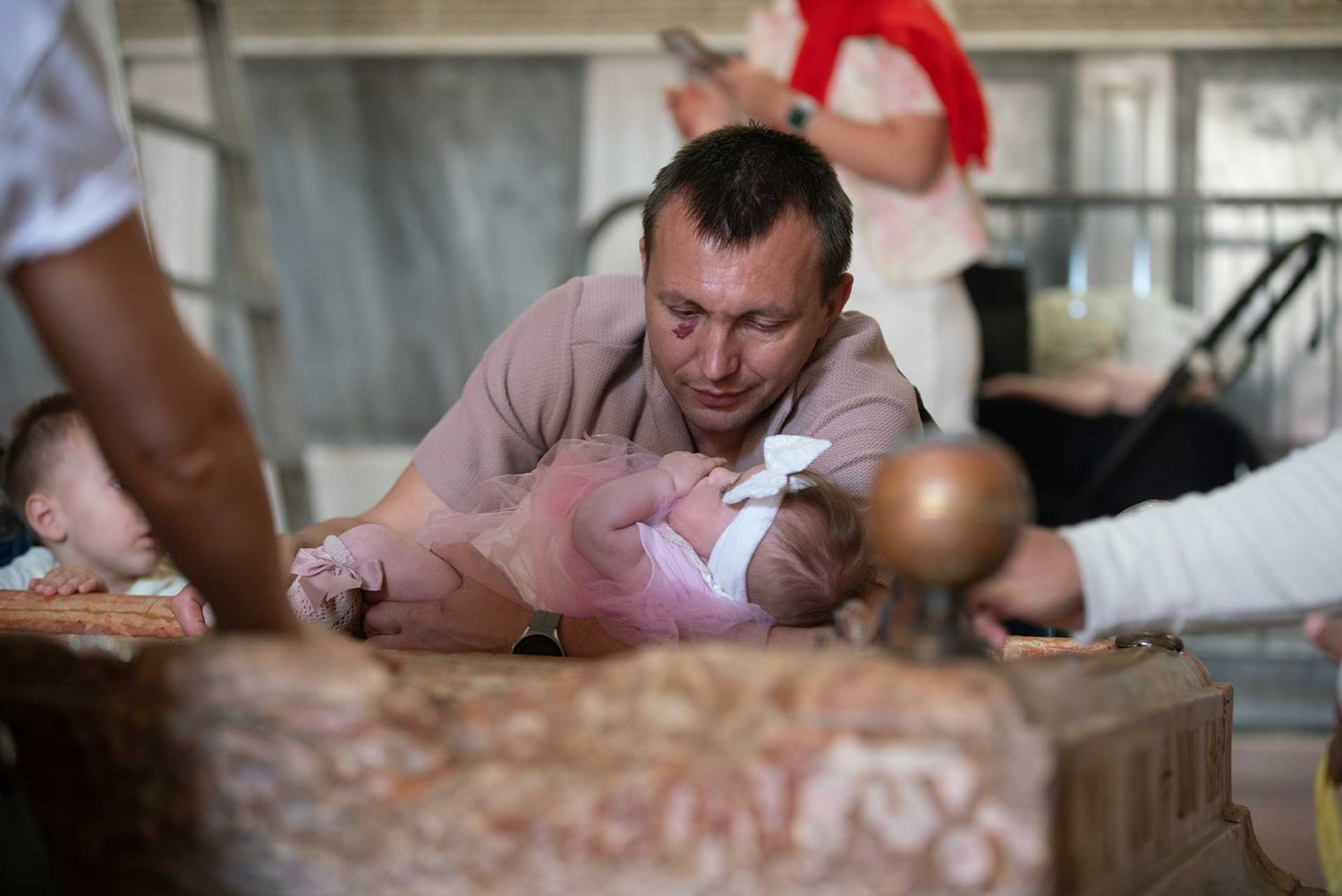 A father gazes at his infant daughter as she lies on Jesus’ tomb at the Church of the Holy Sepulchre on Easter Day, March 31, 2024.