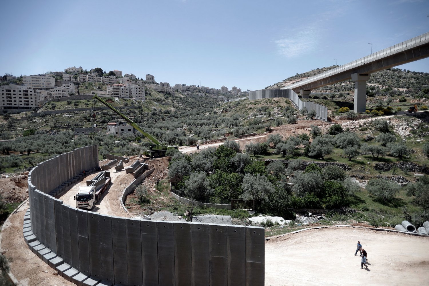 Israeli workers build the Separation Wall in the fertile Cremisan Valley near Beit Jala, April 21, 2016.